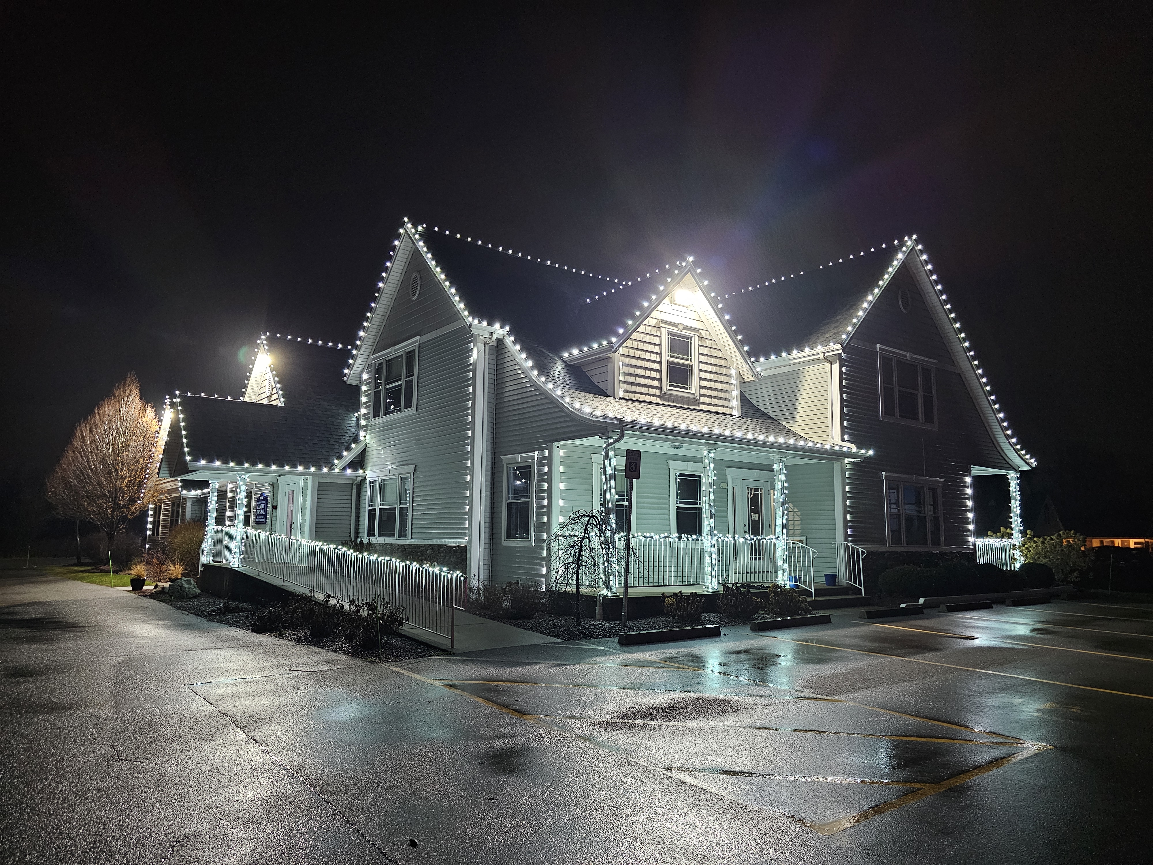 Warm white holiday lighting on a home at dusk by S&K Holiday Lighting