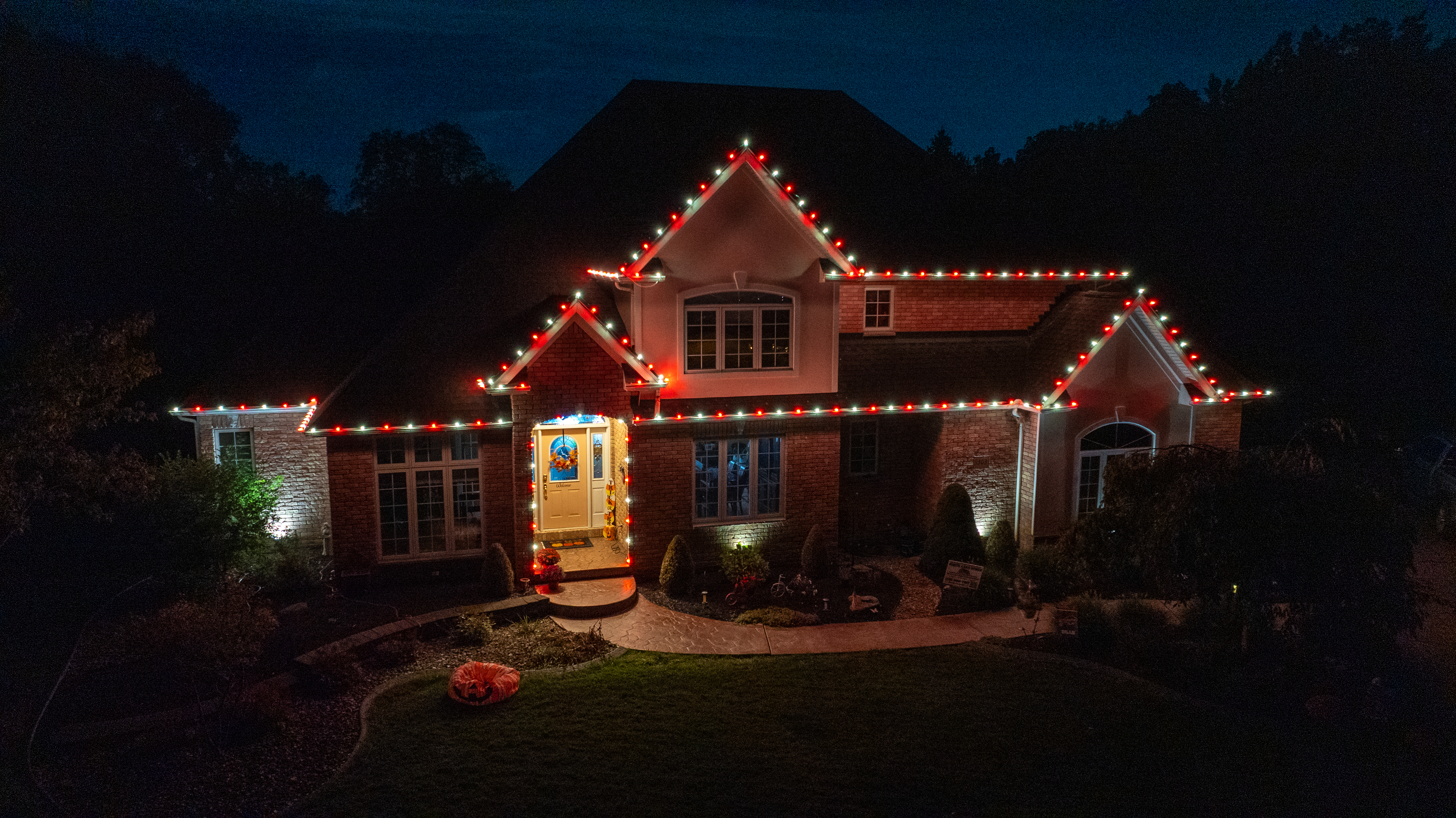 Home with classic red and white Christmas roofline lighting by S&K Holiday Lighting