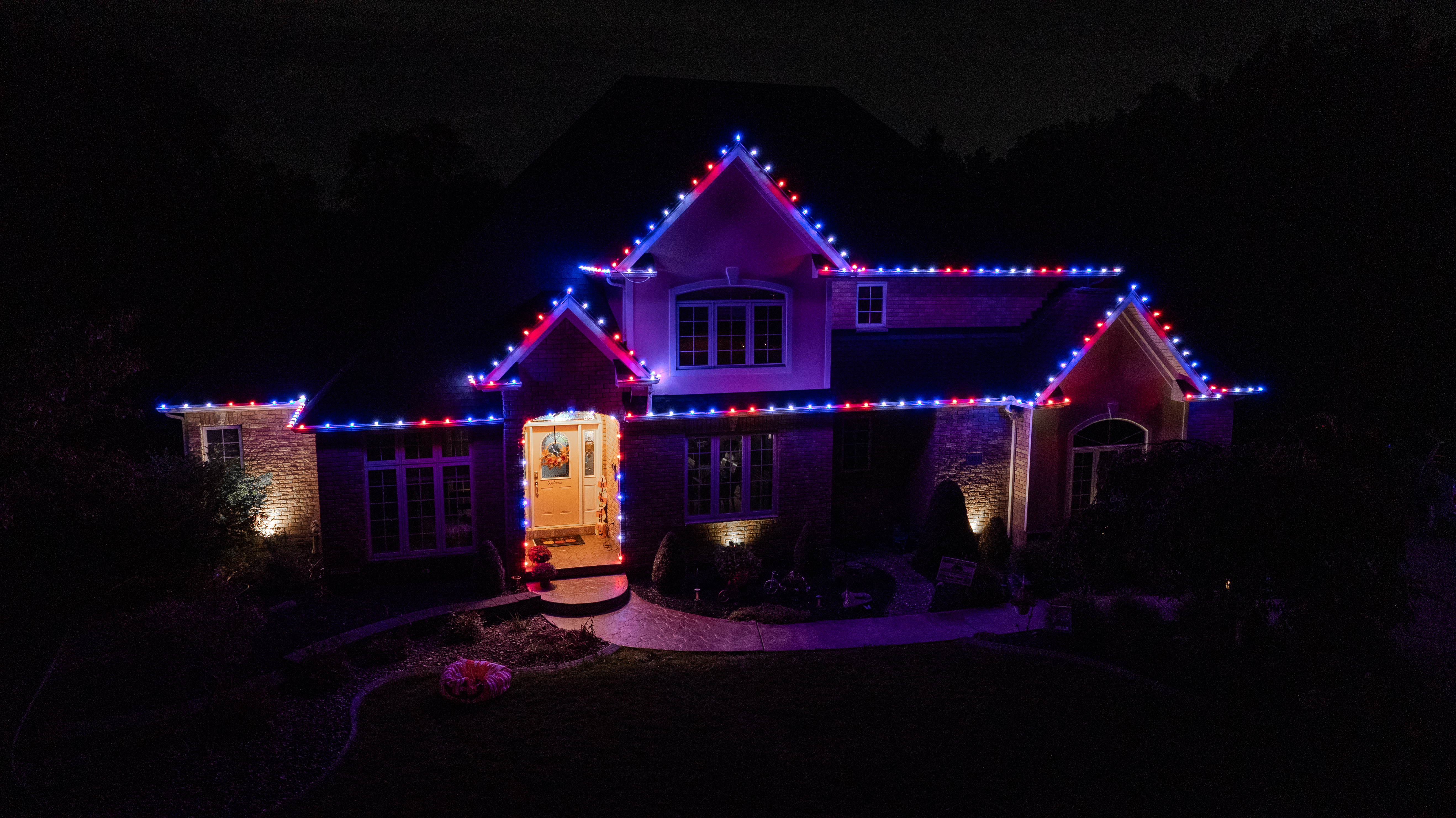 Home with red, white and blue holiday lighting by S&K Holiday Lighting